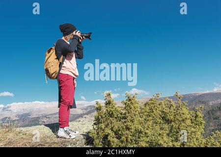 Nature Photographer taking pictures on his dslr camera outdoors during hiking trip on Caucasus. North Caucasus Russia Stock Photo