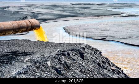 The industrial wastewater is discharged from the pipe into the water Stock Photo