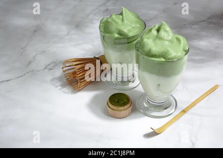 Green matcha dalgona. Trendy hipster drink on marble background. Stock Photo