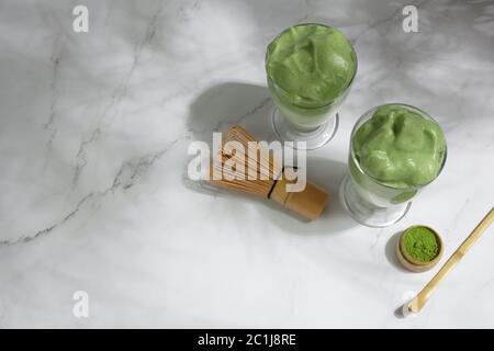 Green matcha dalgona. Trendy hipster drink on marble background. Stock Photo