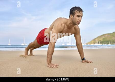 Athletic guy training on beach Stock Photo