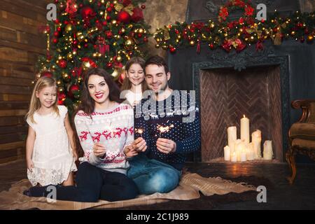 Happy family with sparklers celebrating Christmas Stock Photo