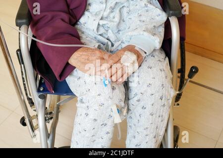 elderly woman hands with intravenous drip on a wheelchair at hospital Stock Photo