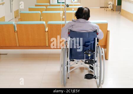 Back view of senior woman sitting on wheelchair in hospital Stock Photo