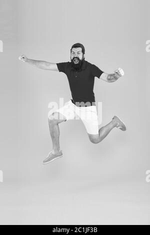 Towards fun. Enjoying active lifestyle. Happy guy jumping. Active bearded man in motion yellow background. Active and energetic hipster. Energy charge. Healthy guy feeling good. Inspired concept. Stock Photo