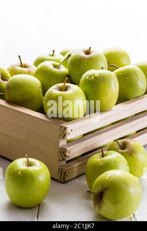 Green apples in crate close up on white background with selective focus Stock Photo