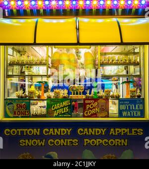 Saint John, NB, Canada - August 29, 2014: A food stand at a carnival at night. Cotton candy and other food in windows, signs tell of other foods. Stock Photo