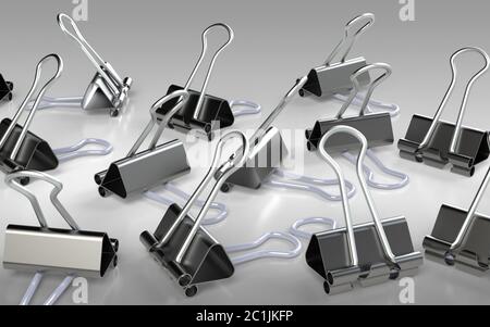 Several binder clips placed on the grey background Stock Photo