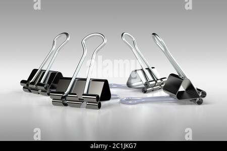 Several binder clips placed on the grey background Stock Photo
