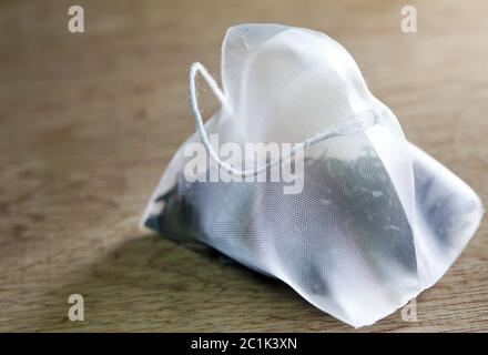 Single bag of elite tea in silk fabric packing on a wooden background Stock Photo