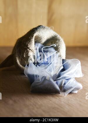 bags of elite tea in silk fabric packing in a canvas bag on a wooden background Stock Photo