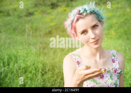 Portrait of a beautiful woman holding a butterfly on her hand in the garden. Beauty portrait. Unity with nature. Ecology concept Stock Photo
