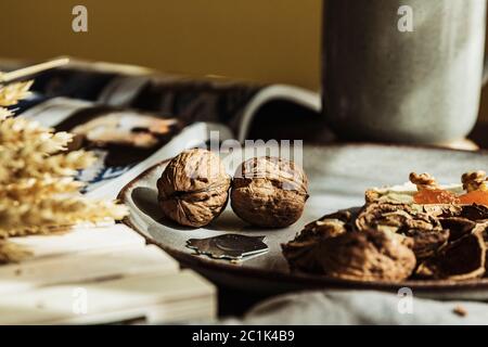 Still life of two beautiful walnuts nuts and a nutpick on a plate in a cozy wooden table for breakfast Stock Photo