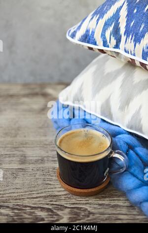 Blue and grey pillows and cup of coffee on the wooden background Stock Photo