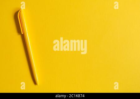 Yellow pen on yellow background with top view and copy space Stock Photo