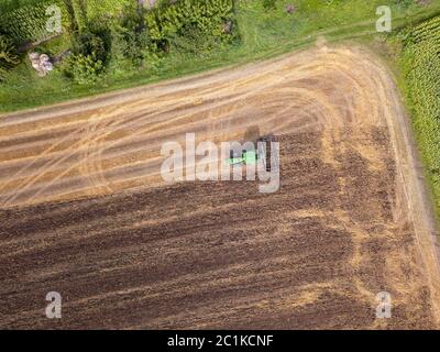 Plowing the ground after harvesting on the field in the autumn time. Top view. Stock Photo