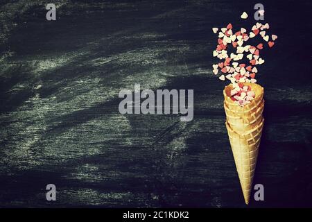 Ice Cream Horn with Sweethearts on a Chalkboard. Love, Valentine's Day or Creative Concept. Top view Stock Photo