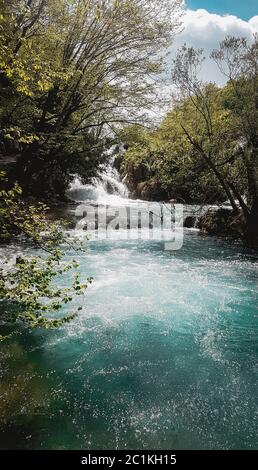 Beautiful Plitvice Lakes in Croatia. Reflected light on water surface, cascade waterfall with raging flow in the background. Peaceful scenic picture Stock Photo
