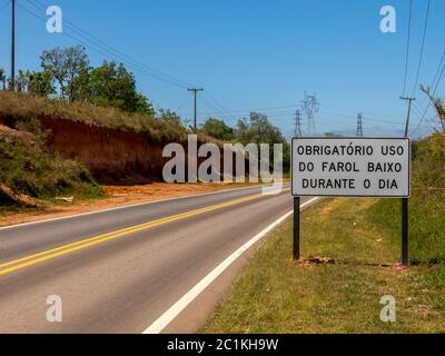 SAO PAULO, BRAZIL - SEPTEMBER 26, 2016 - Road with a new traffic sign informing the new law that requires the use of headlights on even during the day Stock Photo