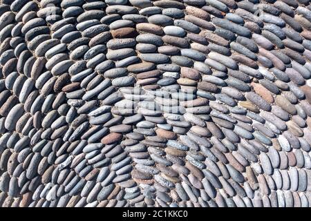 Semicircular pattern of upright placed pebble stones - detail of the design of a pavement Stock Photo