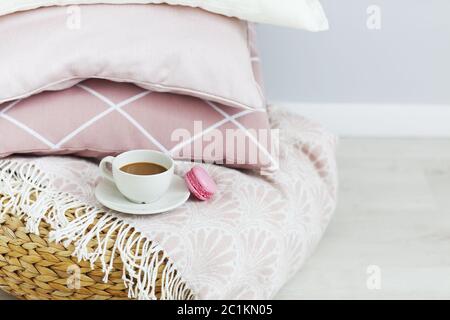 Pink and white pillows and cup of coffee on the wall background Stock Photo