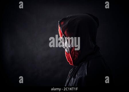 Hooded man in the dark Stock Photo