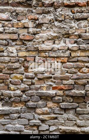 Background of old vintage dirty brick wall with peeling plaster, texture Stock Photo
