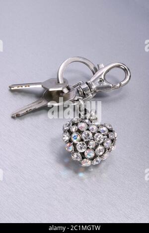 keyring heart with sparkeling gem stones on steel background Stock Photo