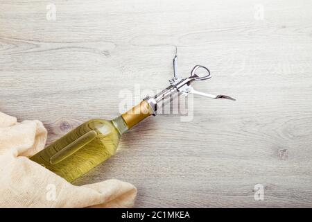 Wine bottle with corkscrew on wooden background Stock Photo