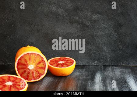 Cut blood oranges on dark board Stock Photo