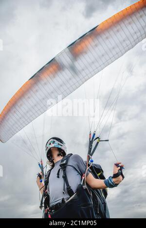 Close-up The paraglider opens his parachute before taking off. Filling the parachute wing with air before takeoff Stock Photo