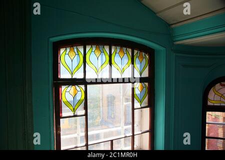 Fragment of a window with a stained-glass window on a staircase of an apartment house on Kolokolnaya street Stock Photo