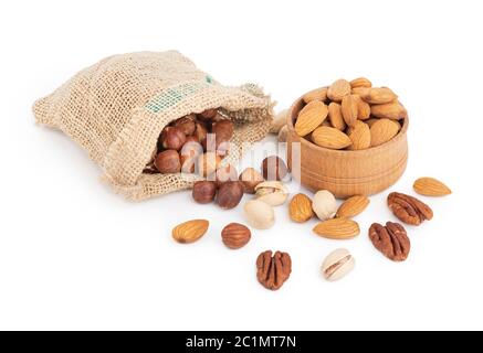Heap of various healthy nuts falling from a sack and almonds in a bowl Stock Photo