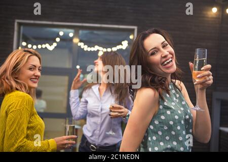 Group of partying girls with flutes with sparkling wine having fun Stock Photo