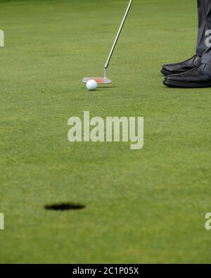 Man putting ball on golf green, close up view Stock Photo