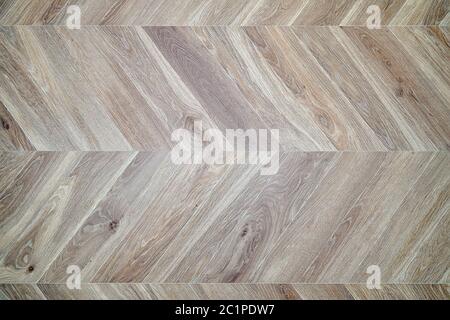 Herringbone wood floor. Texture of wood flooring. Parquet made of bleached oak. Stock Photo