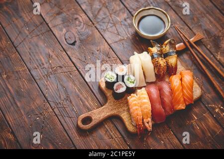 Sushi Set. Different kinds of sushi rolls on wooden serving board Stock Photo