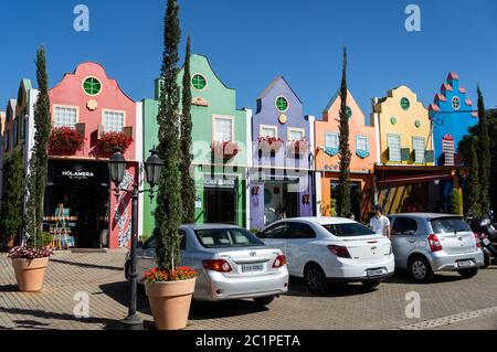 HOLAMBRA, SAO PAULO / BRAZIL - AUGUST 19, 2018: Cars parked in front of the colorful gift stores located at the beginning of Doria Vasconcelos street Stock Photo
