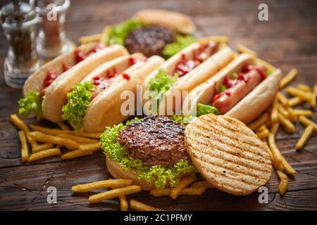 Hot dogs, hamburgers and french fries. Composition of fast food snacks Stock Photo