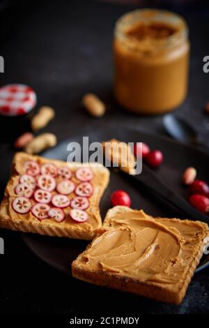 Toasts bread with homemade peanut butter served with fresh slices of cranberries Stock Photo