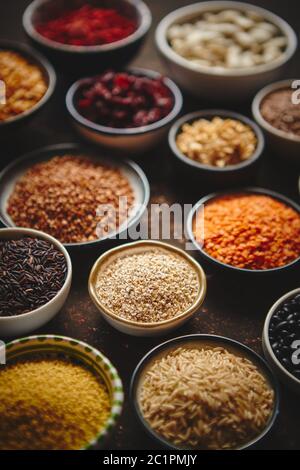 Various superfoods in smal bowls on dark rusty background Stock Photo