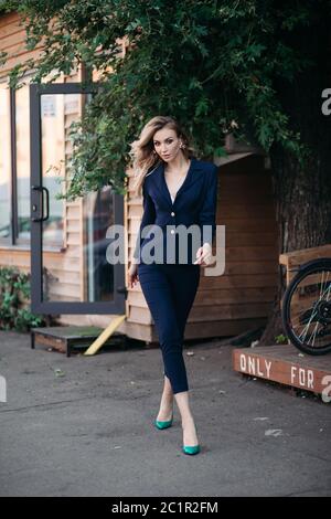 Elegant blonde woman in dark blue suit with gold buttons. Stock Photo