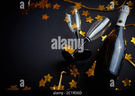 Glasses and bottle of champagne with golden serpentines and confetti Stock Photo