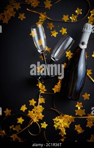 Glasses and bottle of champagne with golden serpentines and confetti Stock Photo