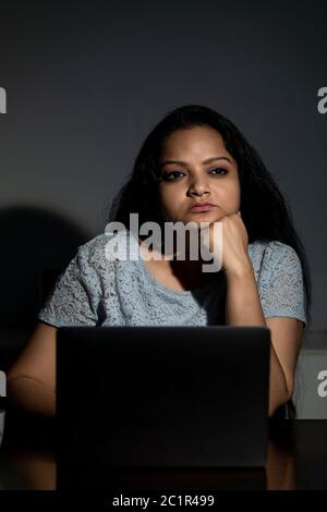 An Indian lady working late at night on her computer Stock Photo