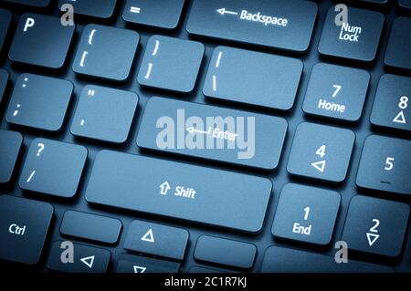 Electronic collection - laptop keyboard. The focus on the Enter key. Toning is blue. Stock Photo