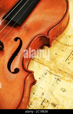 1937 old violin on the background of notes Stock Photo