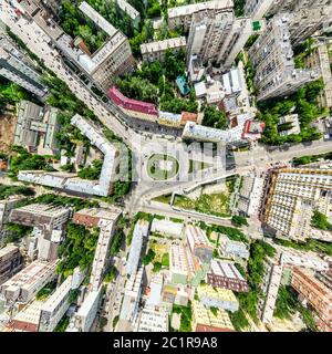 Aerial city view with crossroads and roads, houses, buildings, parks and parking lots. Sunny summer panoramic image Stock Photo