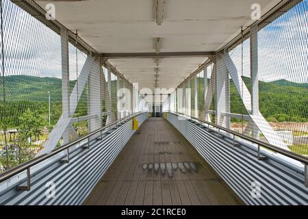 Diminishing perspective view of empty overpass with protective metal fence Stock Photo