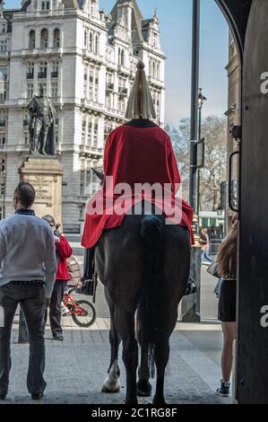 London, UK - March 25, 2012:  Tourists surrounding a mounted soldier at the famous Horseguard's Parade in Whitehall, Westminster. Stock Photo